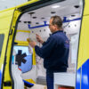 Afbeelding van een werkende man in de binnenkant van een nieuwe ambulance.