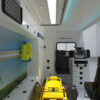 Een render van de binnen kant van een ambulancevoertuig. Vanaf de achterkant gezien.